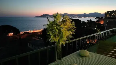a vase on a table with a view of the ocean at Appartement vue mer panoramique, plage 150M, terrasse, parking privé, clim in Cannes