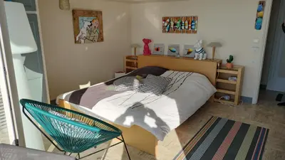 a bedroom with a bed and a chair at Appartement vue mer panoramique, plage 150M, terrasse, parking privé, clim in Cannes