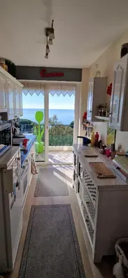 a kitchen with a view of the ocean at Appartement vue mer panoramique, plage 150M, terrasse, parking privé, clim in Cannes