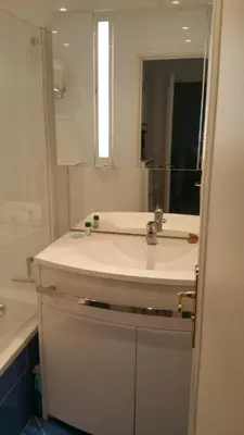 a bathroom with a white sink and a mirror at Moderne Appartement Cannes Californie in Cannes