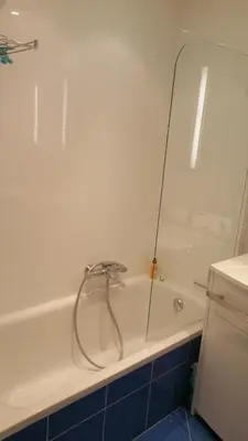 a white bath tub with a shower in a bathroom at Moderne Appartement Cannes Californie in Cannes