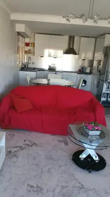 a living room with a red couch in a kitchen at Moderne Appartement Cannes Californie in Cannes