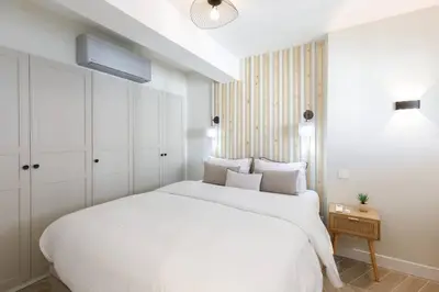 a white bedroom with a large white bed and a table at Martinez area Superb 1 bed w XXL terrace in Cannes