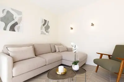 a living room with a white couch and a table at Martinez area Superb 1 bed w XXL terrace in Cannes