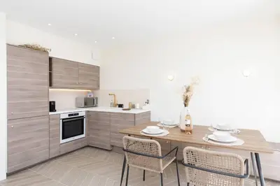 a kitchen with a wooden table and chairs in a room at Martinez area Superb 1 bed w XXL terrace in Cannes