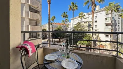 a table on a balcony with a view of a city at Modern 2 Bd Next To Rue Dantibes in Cannes