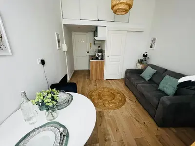 a living room with a white table and a couch at Joli Studio sur le Port in Cannes