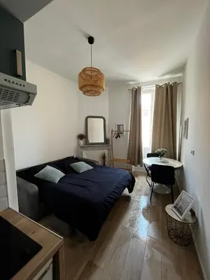 a bedroom with a bed and a table in it at Joli Studio sur le Port in Cannes