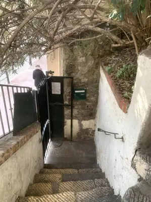 a person is standing on a railing near a door at Joli Studio sur le Port in Cannes