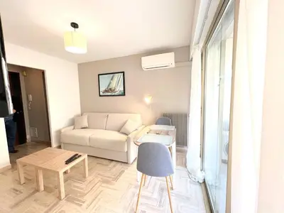 a living room with a white couch and a table at LM Studio by Welcome to Cannes in Cannes