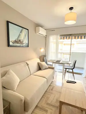 a living room with a white couch and a table at LM Studio by Welcome to Cannes in Cannes