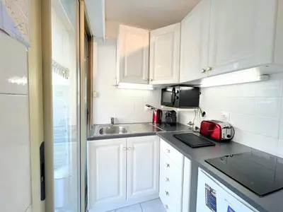 a small kitchen with white cabinets and a sink at LM Studio by Welcome to Cannes in Cannes