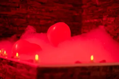 two red hearts on a table with lit candles at LE COCON- Jacuzzi & Sauna privés By SweetDreams in Le Cannet