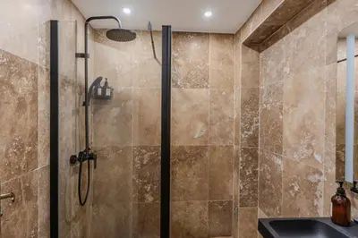 a shower with a glass door in a bathroom at LE COCON- Jacuzzi & Sauna privés By SweetDreams in Le Cannet