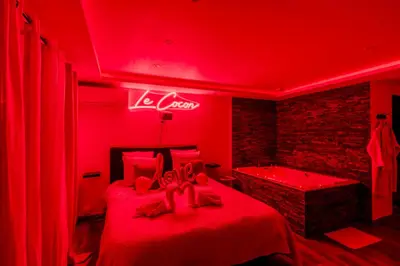 a red room with a bed and a bath tub at LE COCON- Jacuzzi & Sauna privés By SweetDreams in Le Cannet