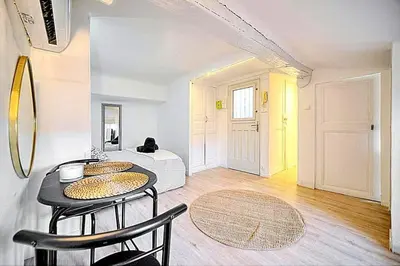 a living room with a table and chairs and a bed at Palais des festivals et rue d'Antibes charme mansardes in Cannes