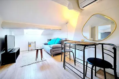 a living room with a couch and a mirror at Palais des festivals et rue d'Antibes charme mansardes in Cannes