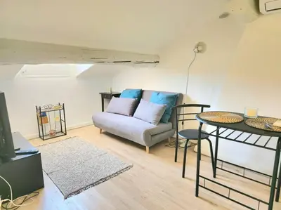 a living room with a couch and a table at Palais des festivals et rue d'Antibes charme mansardes in Cannes