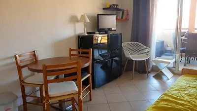 a room with a table and chairs and a television at Cannes Chataignier in Cannes