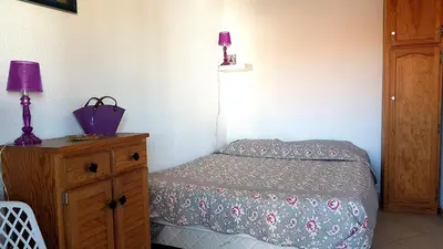 a bedroom with a bed and a dresser with a purple lamp at Cannes Chataignier in Cannes