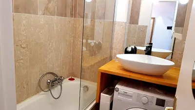 a bathroom with a sink and a washing machine at Cannes Chataignier in Cannes