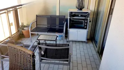 a balcony with a stove and a table and chairs at Cannes Chataignier in Cannes