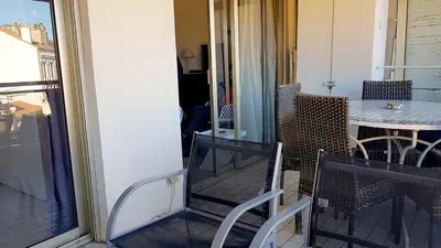 a balcony with a table and chairs and a glass door at Cannes Chataignier in Cannes
