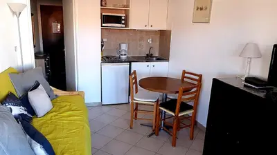 a room with a kitchen and a table and a couch at Cannes Chataignier in Cannes