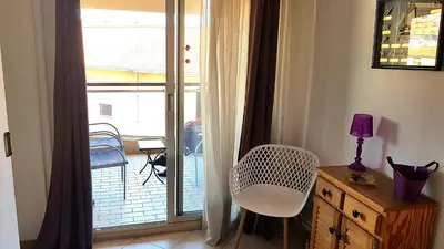 a room with a window with a chair and a table at Cannes Chataignier in Cannes