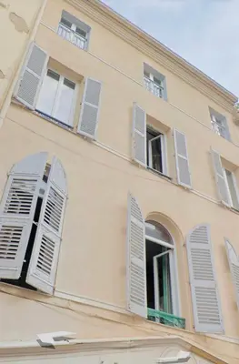 a building with white shutters on its windows at 1 Bedroom flat 4ppl Cannes Center Croisette Banane in Cannes