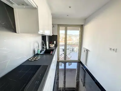 a kitchen with black counter tops and a window at SUQ3 - Très beau 2 pièces avec terrasse in Cannes