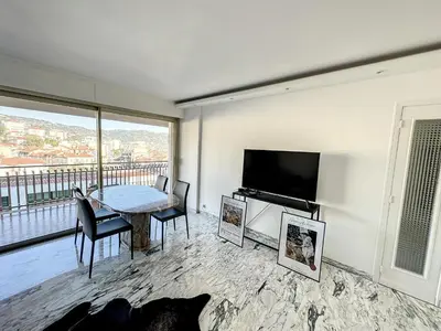 a living room with a table and a flat screen tv at SUQ3 - Très beau 2 pièces avec terrasse in Cannes
