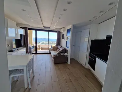 a living room with a couch and a kitchen with a view of the ocean at CANNES VILLA FRANCIA in Cannes