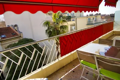 a balcony with a red and white railing and chairs at Ref JUAS - Palmes d'Or Properties in Cannes