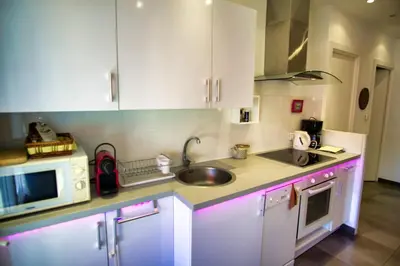 a kitchen with white cabinets and a sink and a microwave at Ref JUAS - Palmes d'Or Properties in Cannes