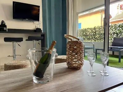 a bottle of wine and two glasses on a table at 2 pièces près de la Croisette in Cannes
