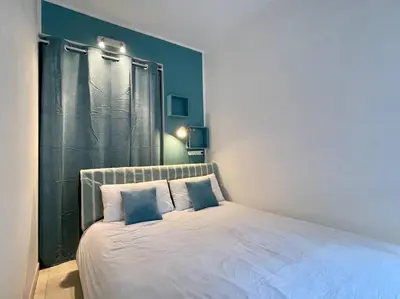 a white bed with two pillows in a bedroom at 2 pièces près de la Croisette in Cannes