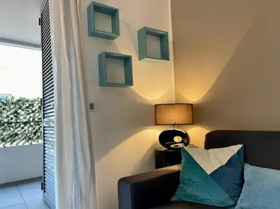 a living room with a couch and a lamp at 2 pièces près de la Croisette in Cannes