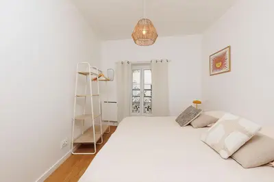 a white bedroom with a large bed and a ladder at Pegase in Cannes