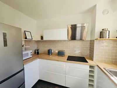 a kitchen with white cabinets and a counter top at Le Week Riviera - Spacieux 3 étoiles-Coeur de Cannes - Palais des Festivals- Terrasse - Clim- Garage in Cannes