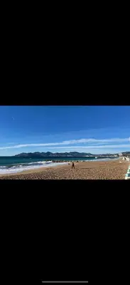 a person walking on a beach near the ocean at Le Week Riviera - Spacieux 3 étoiles-Coeur de Cannes - Palais des Festivals- Terrasse - Clim- Garage in Cannes