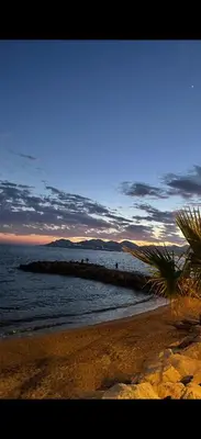 a beach with a group of people standing on a rock in the water at Le Week Riviera - Spacieux 3 étoiles-Coeur de Cannes - Palais des Festivals- Terrasse - Clim- Garage in Cannes