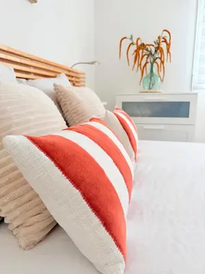 a red and white striped pillow on a bed at Le Week Riviera - Spacieux 3 étoiles-Coeur de Cannes - Palais des Festivals- Terrasse - Clim- Garage in Cannes