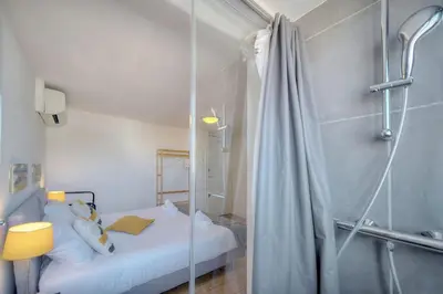 a small bedroom with a shower and a bed at IMMOGROOM - 2 min from the Palais des Festival and the beaches - ac in Cannes