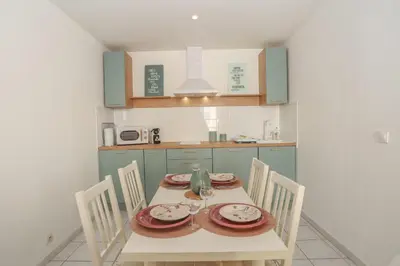 a kitchen with a table and chairs in a room at IMMOGROOM - Best place in Cannes Center - AC - 5 min from beaches in Cannes