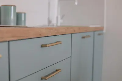 a kitchen with white cabinets and a wooden counter top at IMMOGROOM - Best place in Cannes Center - AC - 5 min from beaches in Cannes