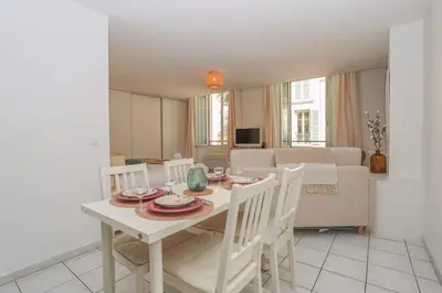 a dining room and living room with a table and chairs at IMMOGROOM - Best place in Cannes Center - AC - 5 min from beaches in Cannes