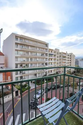 a chair on a balcony with a view of a street at IMMOGROOM - Duplex with air conditioner - 5 min from the beach - Suquet in Cannes