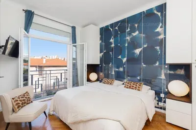 a bedroom with a large bed and a large window at Alba in Cannes
