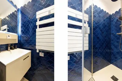 a bathroom with blue tiles and a shower at Alba in Cannes